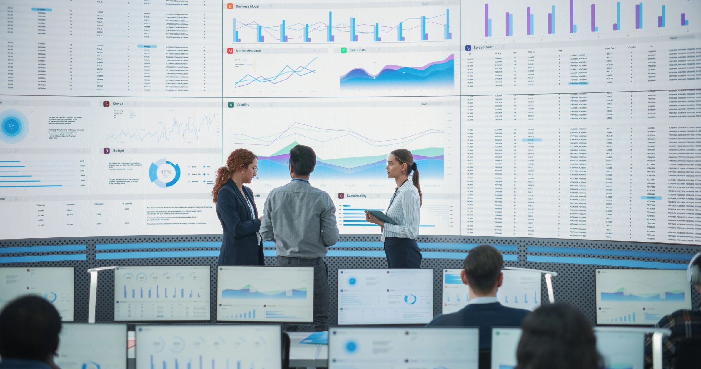 Technology professionals reviewing data on large screens