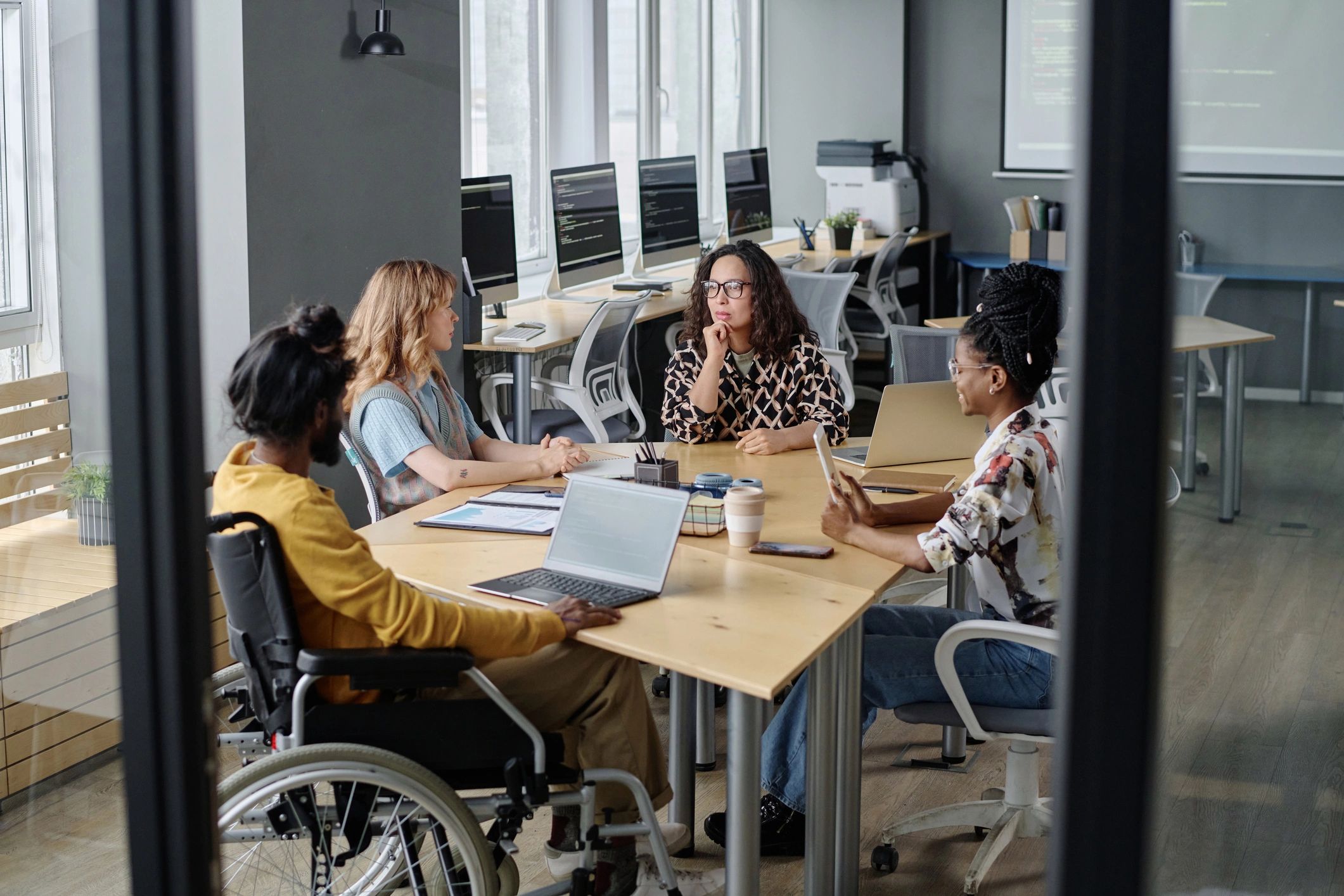 Diverse team discussing business and technology in a modern office