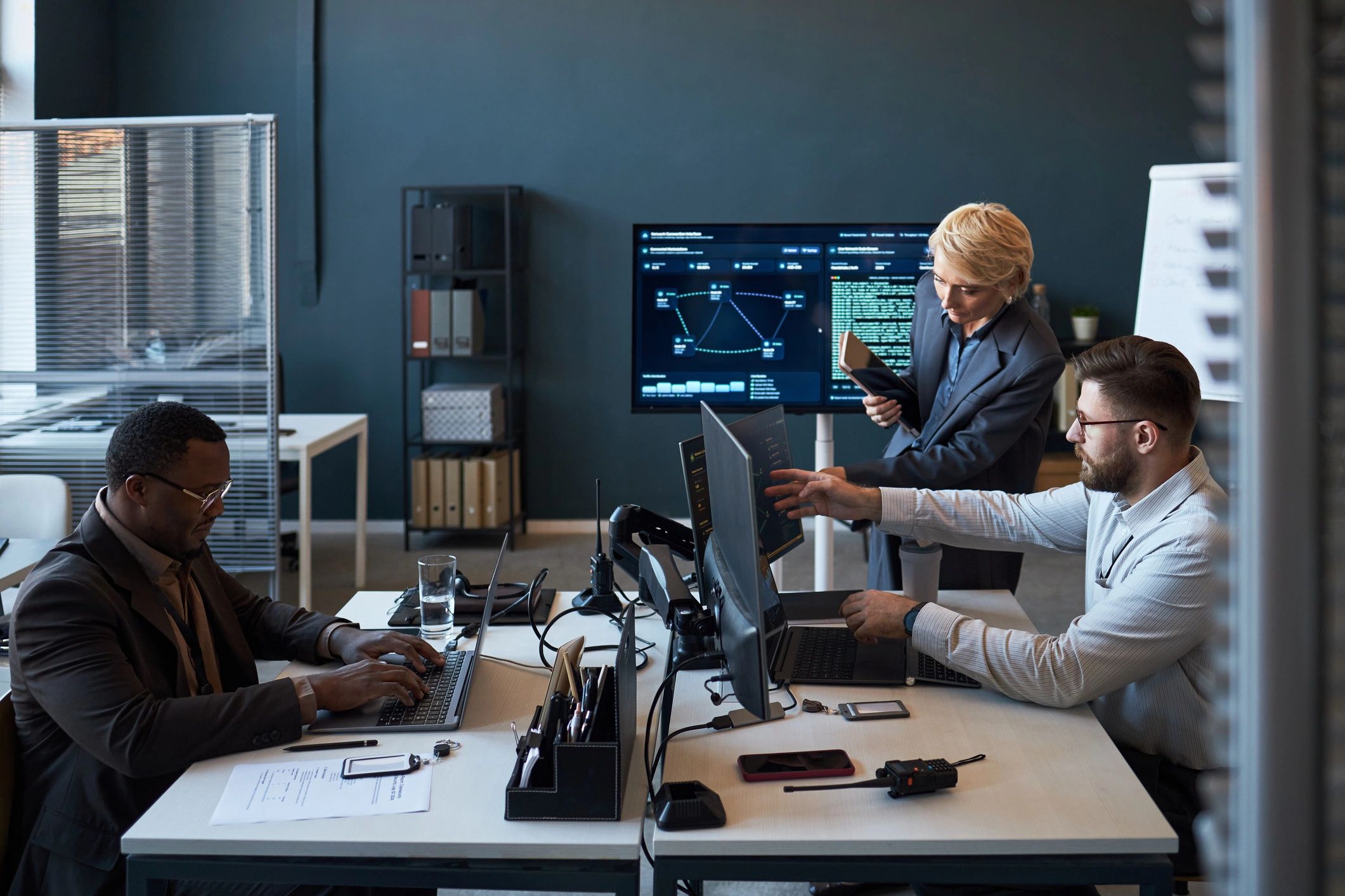 Business team reviewing technology dashboards in a modern office